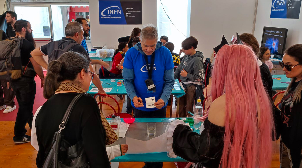 Persone che giocano allo stand INFN a Play 2023
